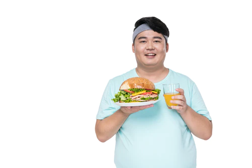 肥胖的年轻男子拿着汉堡和饮料图片