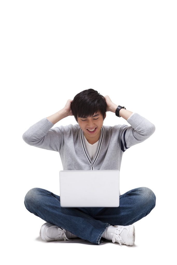 年轻男人坐在地上使用笔记本电脑图片