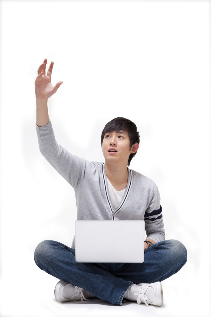 年轻男人坐在地上使用笔记本电脑