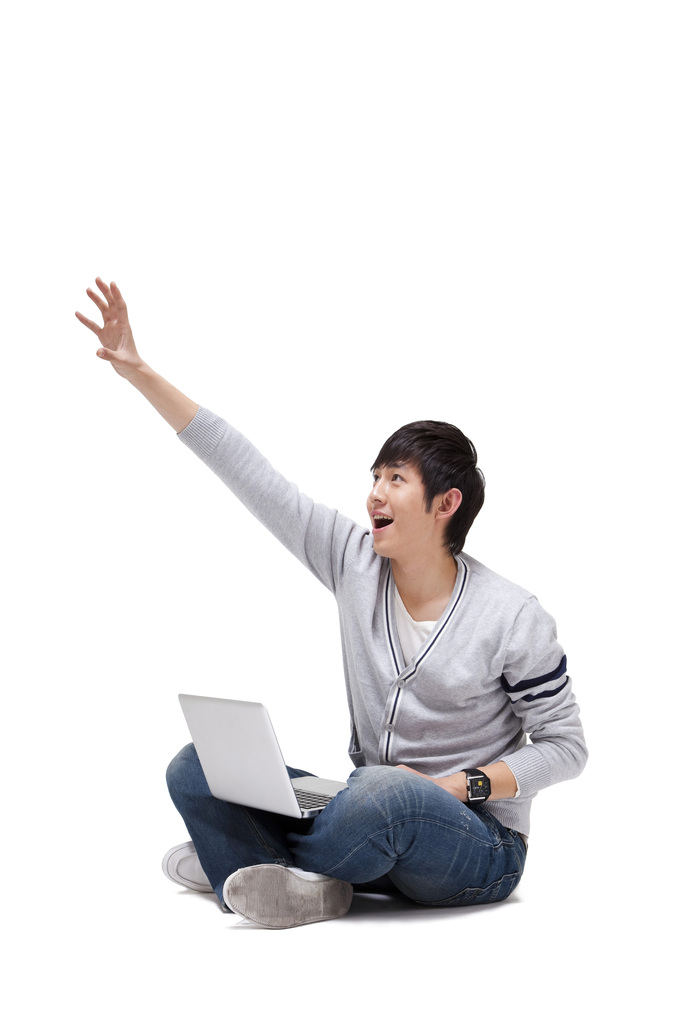 年轻男人坐在地上使用笔记本电脑图片