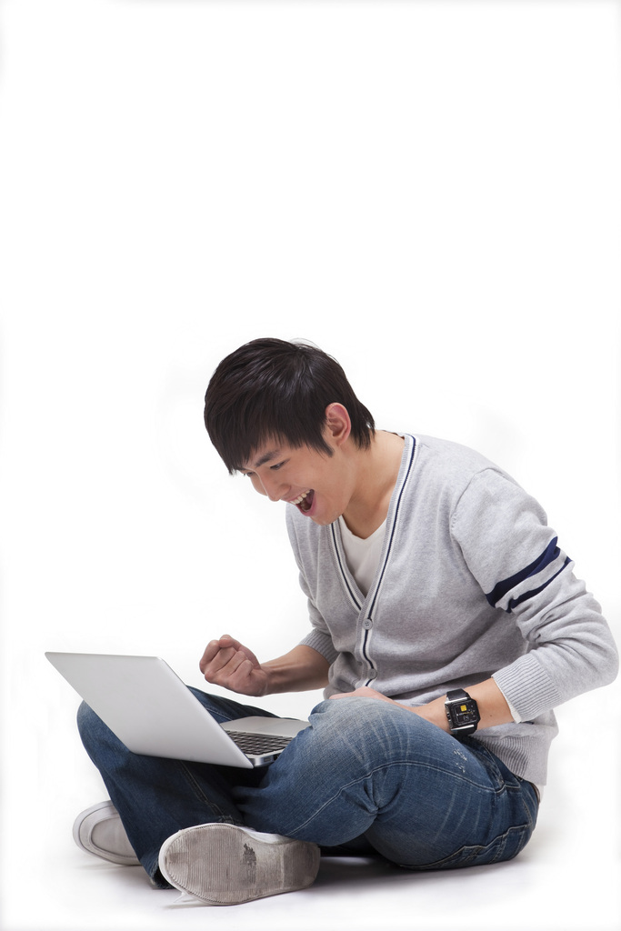 年轻男人坐在地上使用笔记本电脑