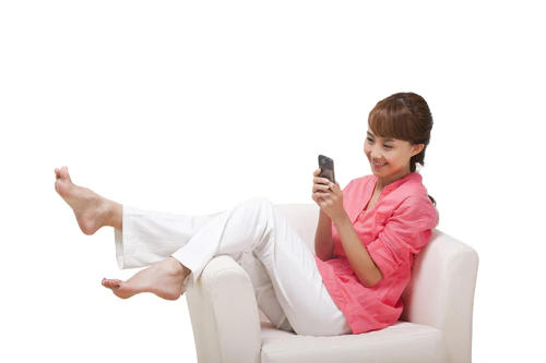 年轻女人坐在沙发上打手机图片