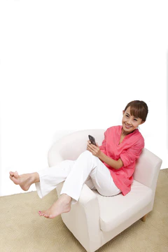 年轻女人坐在沙发上打手机图片
