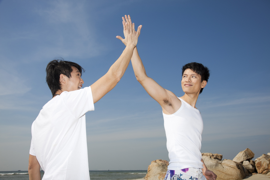 海边休闲装年轻男人击掌