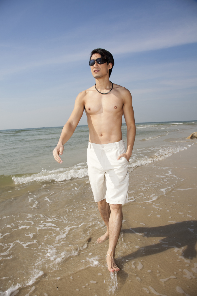 海边休闲装年轻男人漫步图片