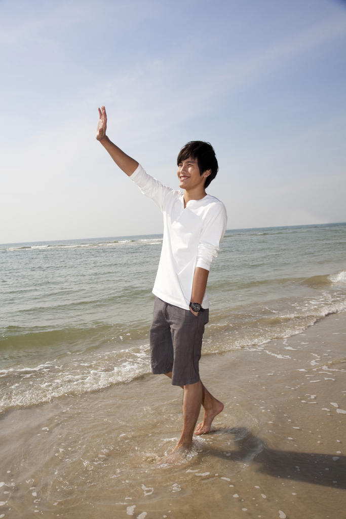 海边休闲装年轻男人漫步图片