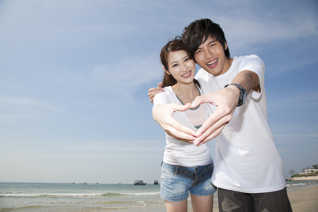 年轻情侣在海边度假图片
