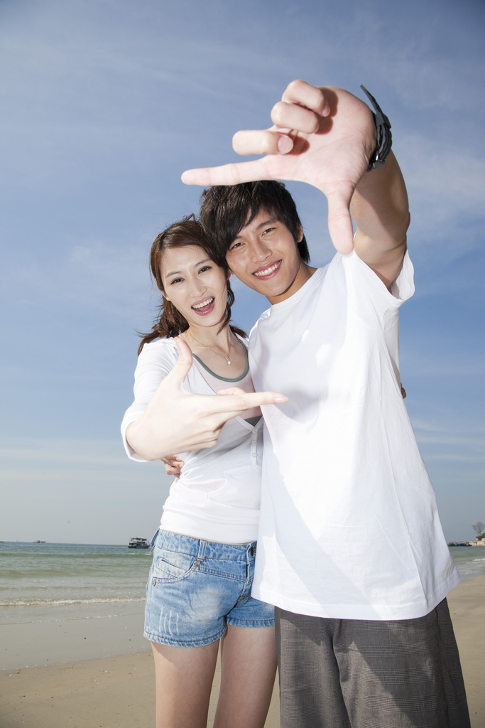 年轻情侣在海边度假图片