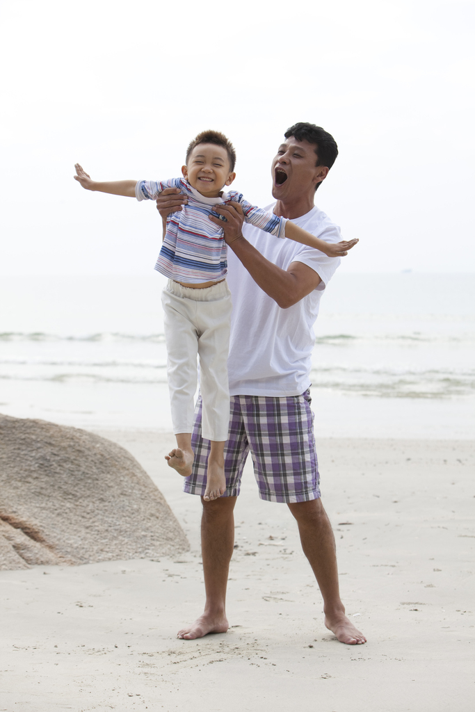 中年男人和小男孩在海边度假图片