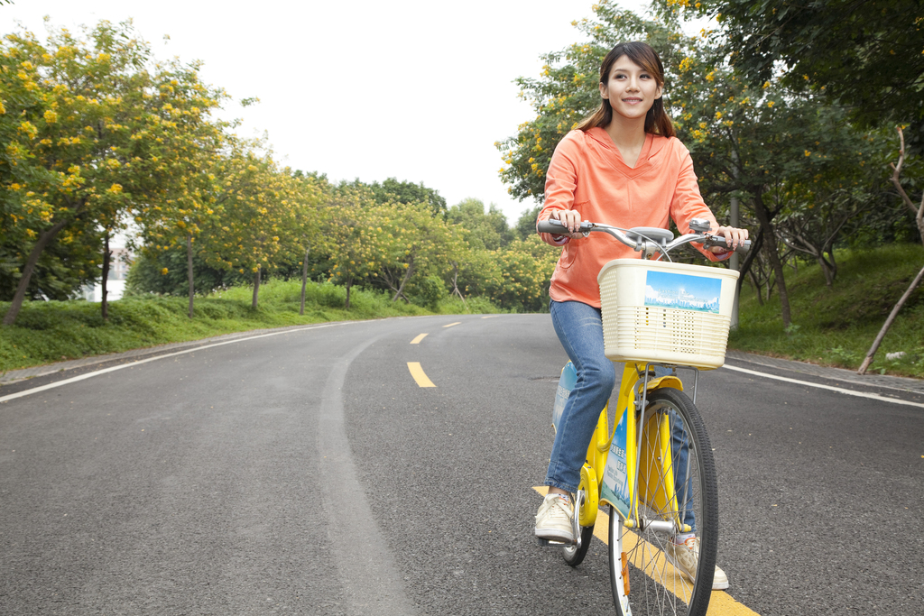 一个年轻女大学生在校园里骑车