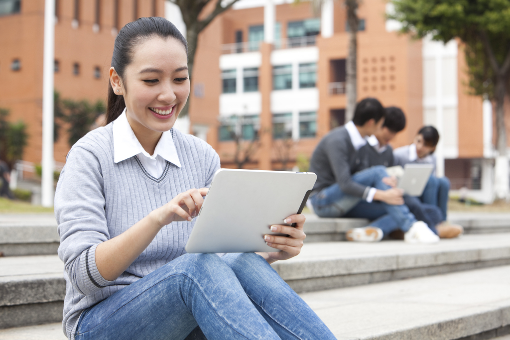 年轻大学生在校园里使用平板电脑图片