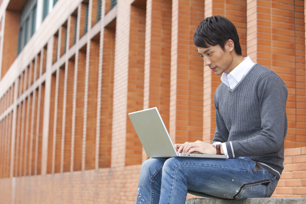 年轻大学生在校园里使用笔记本电脑