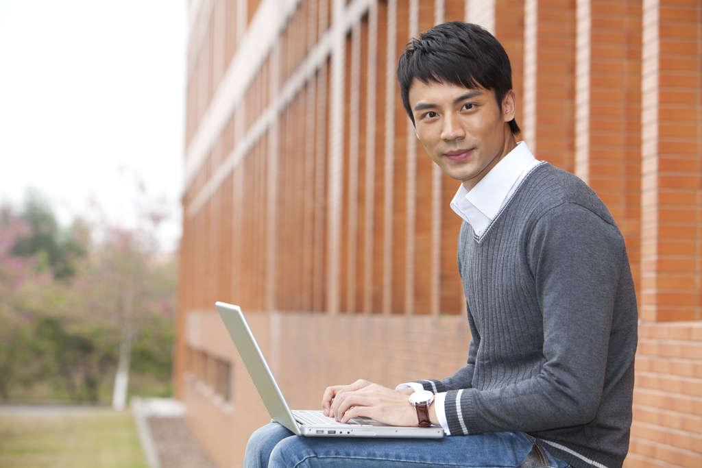 年轻大学生在校园里使用笔记本电脑