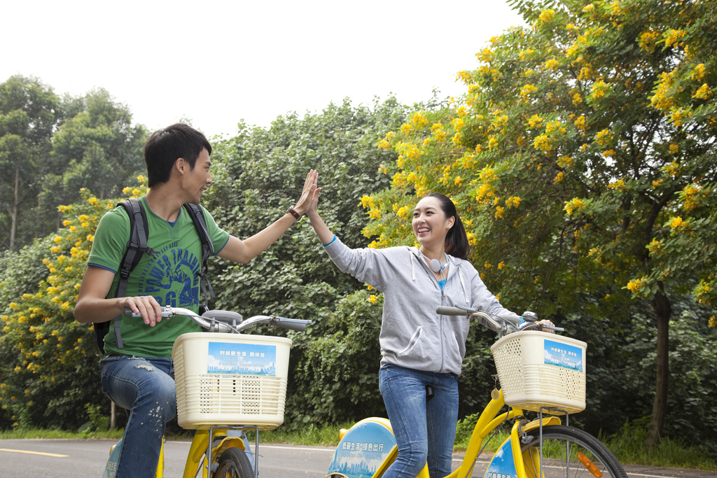 年轻大学生在校园里骑车