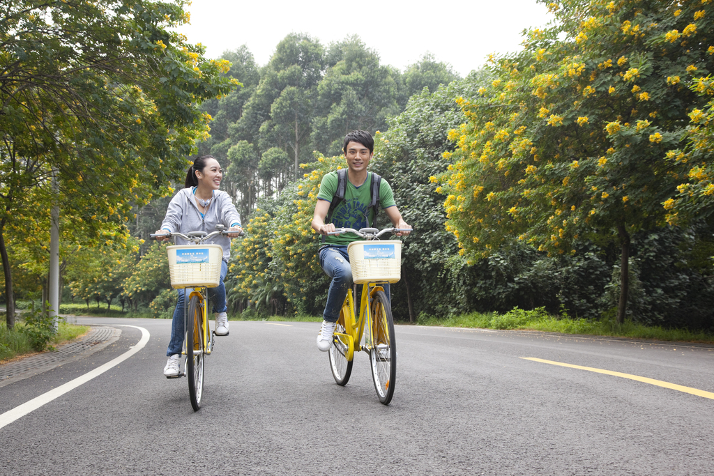 年轻大学生在校园里骑车