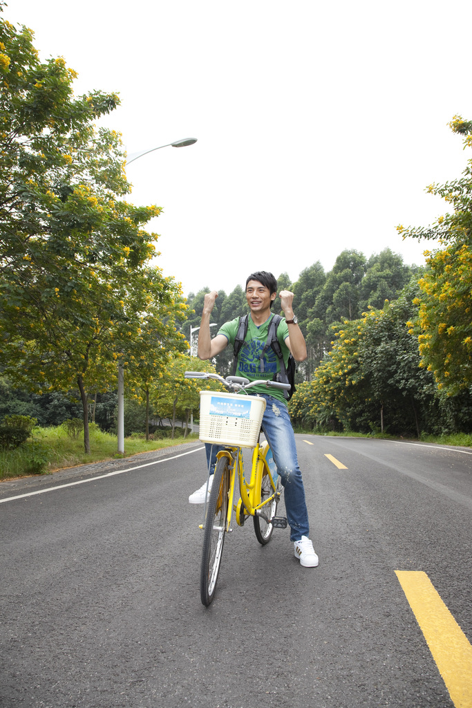 年轻大学生在校园里骑车