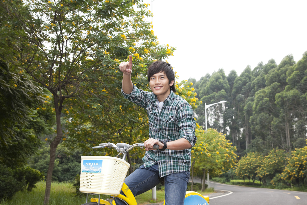 年轻大学生在校园里骑车