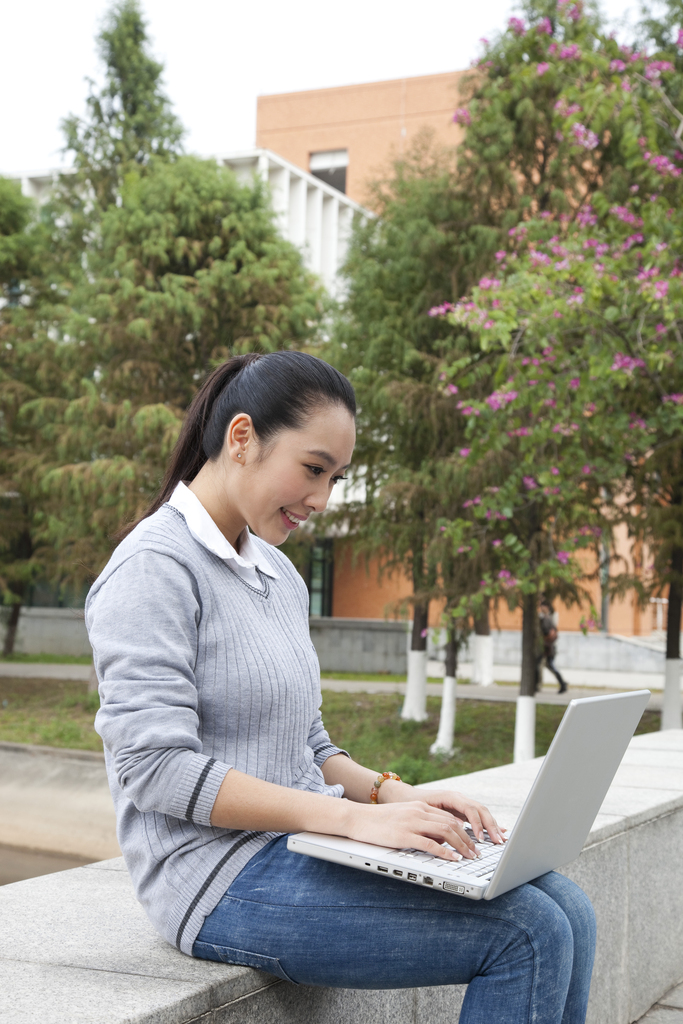 年轻大学生在校园里使用笔记本电脑