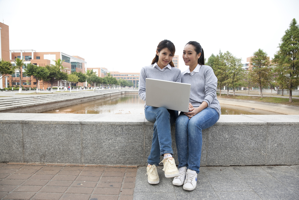 年轻大学生在校园里使用笔记本电脑