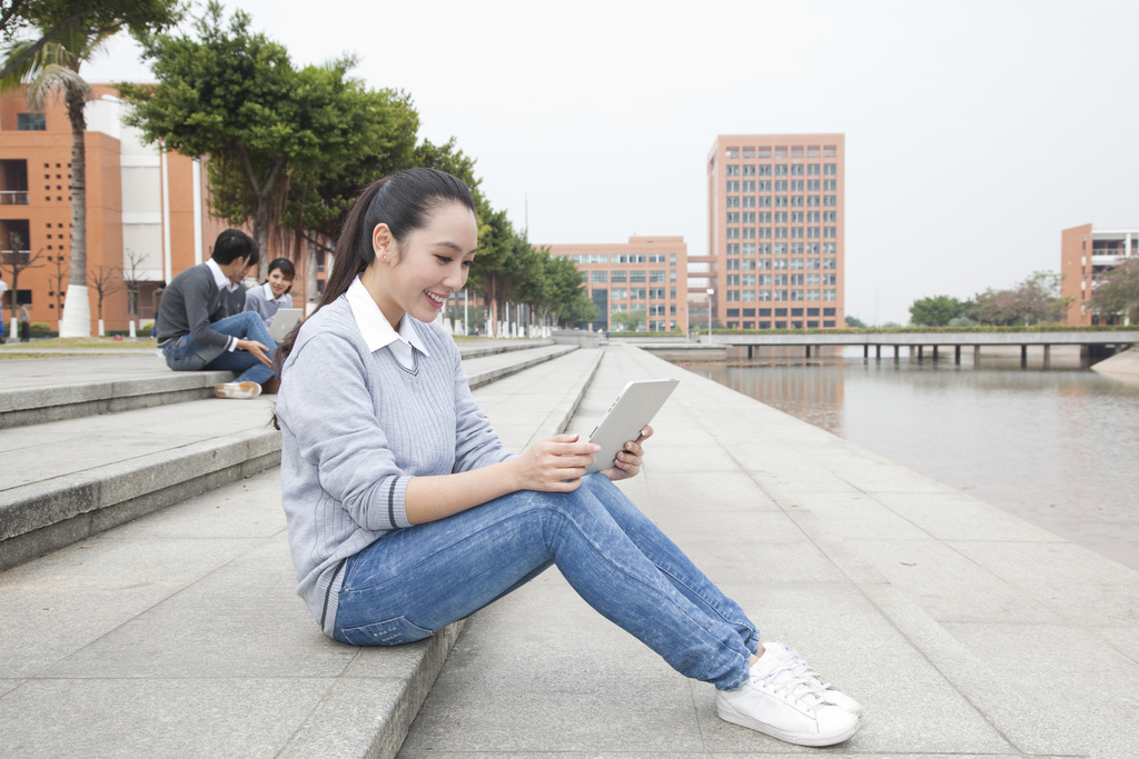 年轻大学生在校园里使用平板电脑图片