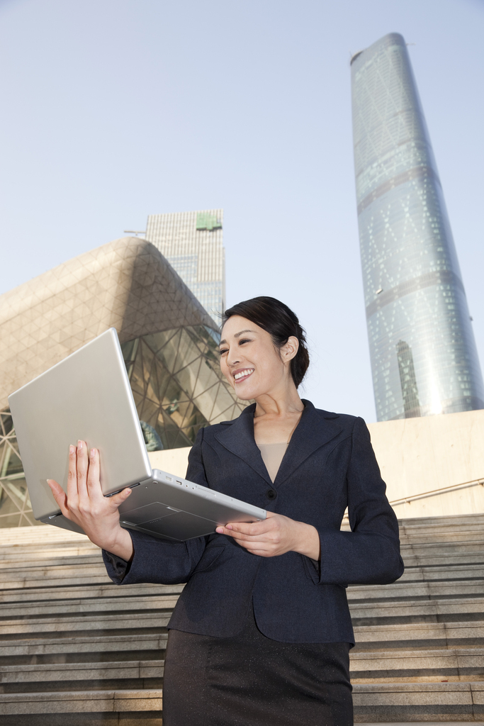 年轻商务女士在办公楼外图片