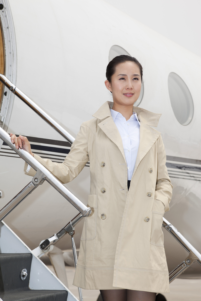 商务女士站在私人飞机悬梯上图片