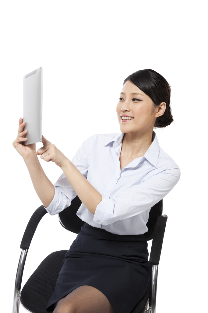 棚拍年轻商务女士坐在办公椅上使用平板电脑
