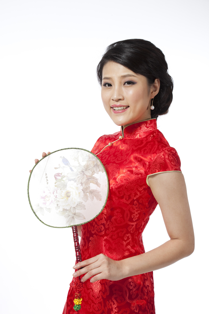 棚拍节日身穿红色旗袍的年轻女人拿着扇子