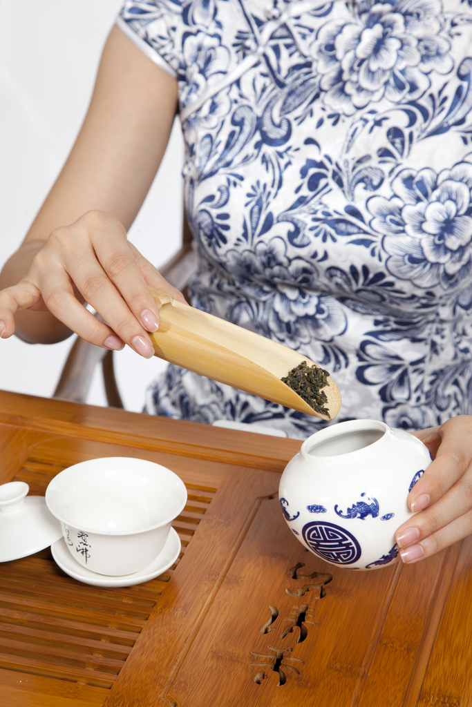 棚拍身穿旗袍的年轻女人茶艺表演