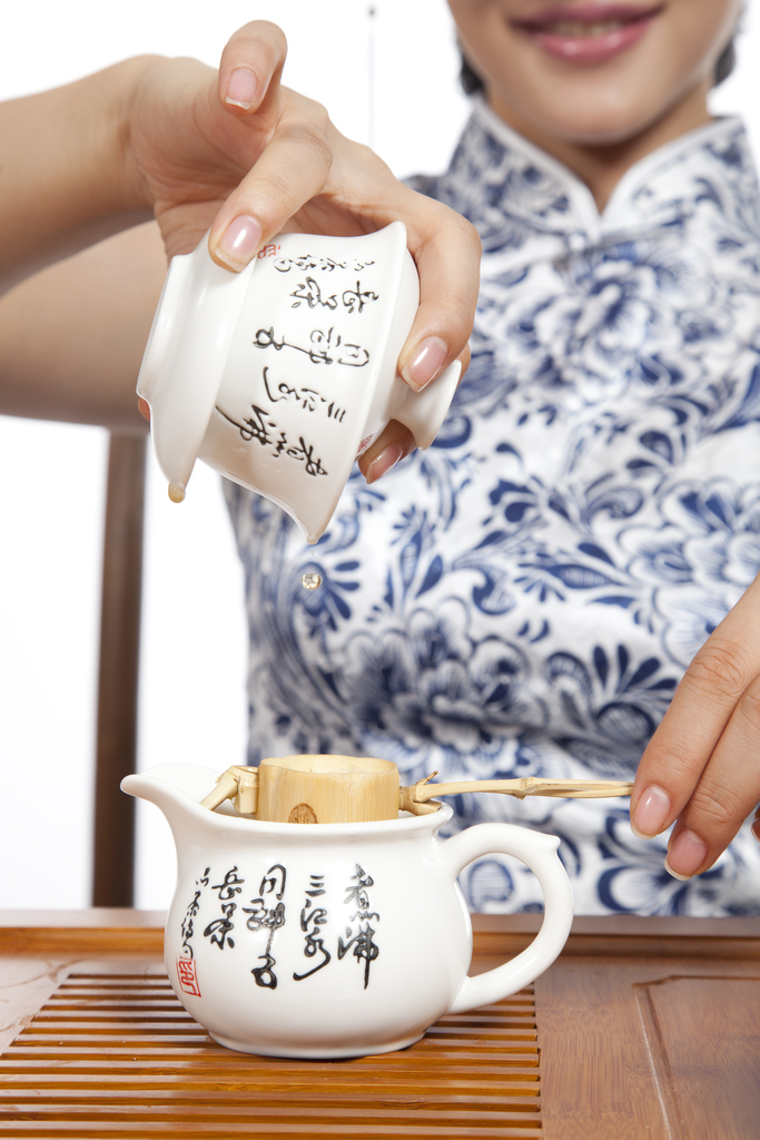 棚拍身穿旗袍的年轻女人茶艺表演