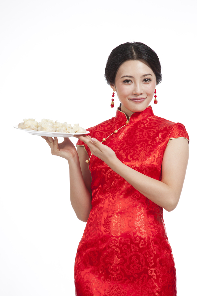 棚拍节日身穿红色旗袍的年轻女人端着饺子图片