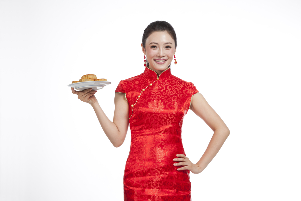棚拍节日身穿红色旗袍的年轻女人端着月饼图片