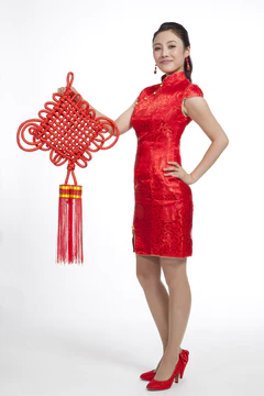 棚拍节日身穿红色旗袍的年轻女人拿着中国结图片