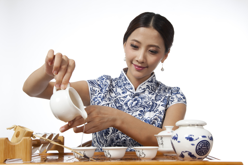 棚拍身穿旗袍的年轻女人茶艺表演