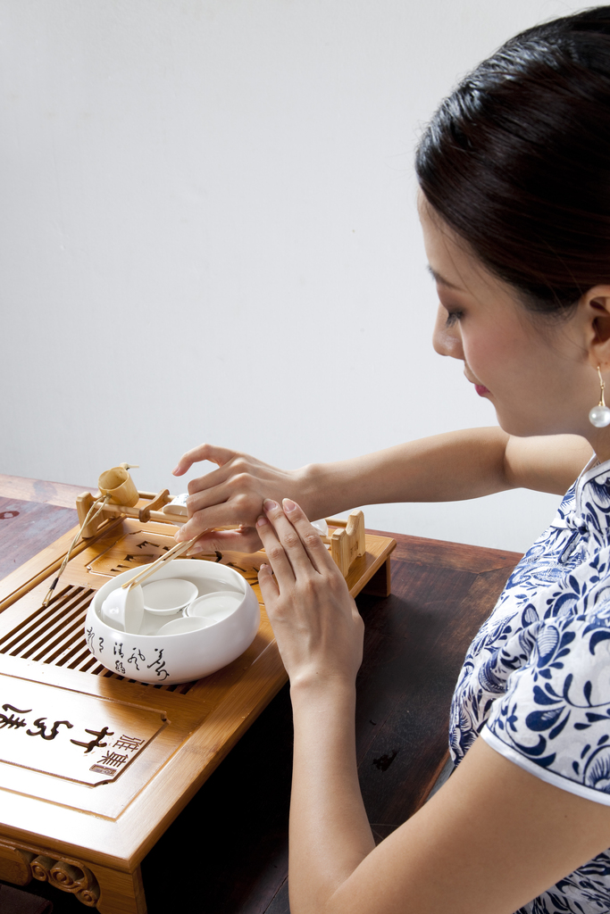 棚拍身穿旗袍的年轻女人茶艺表演