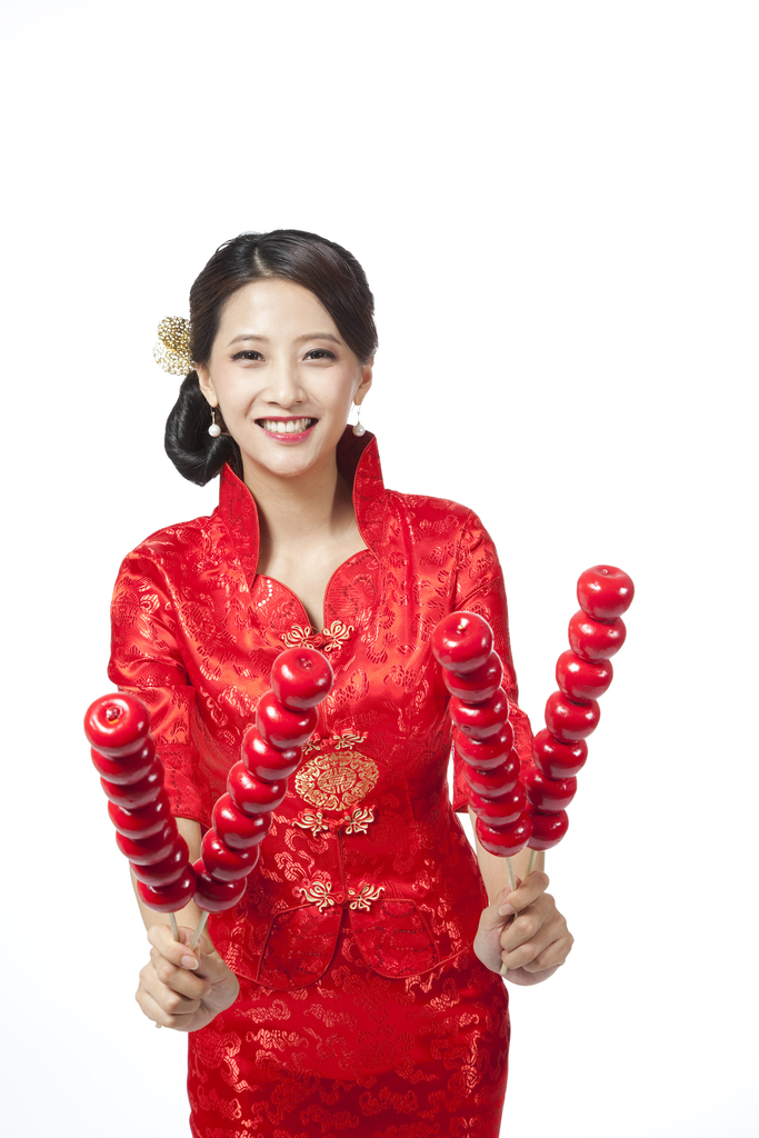 棚拍身穿红色旗袍的年轻女人拿着糖葫芦