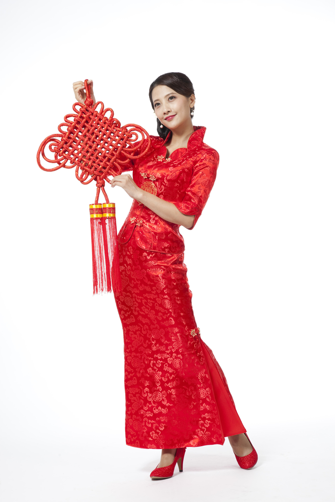 棚拍节日身穿红色旗袍的年轻女人拿着中国结