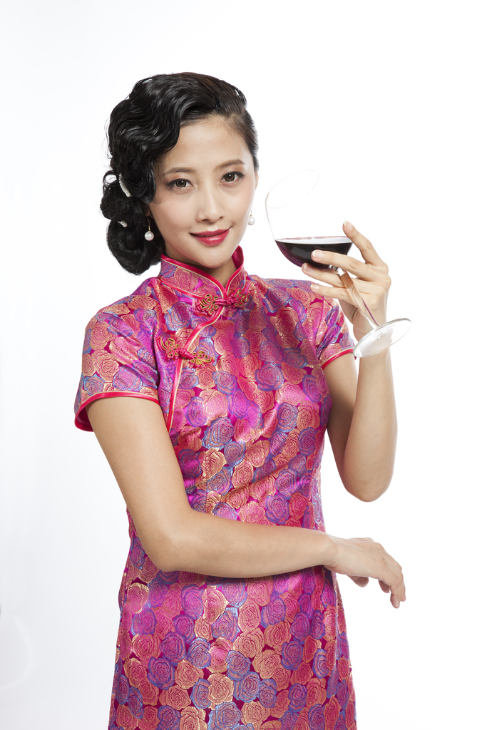 棚拍身穿旗袍的年轻女人举杯图片