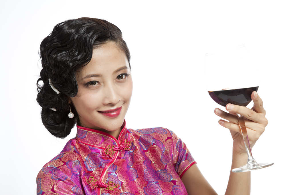 棚拍身穿旗袍的年轻女人举杯图片
