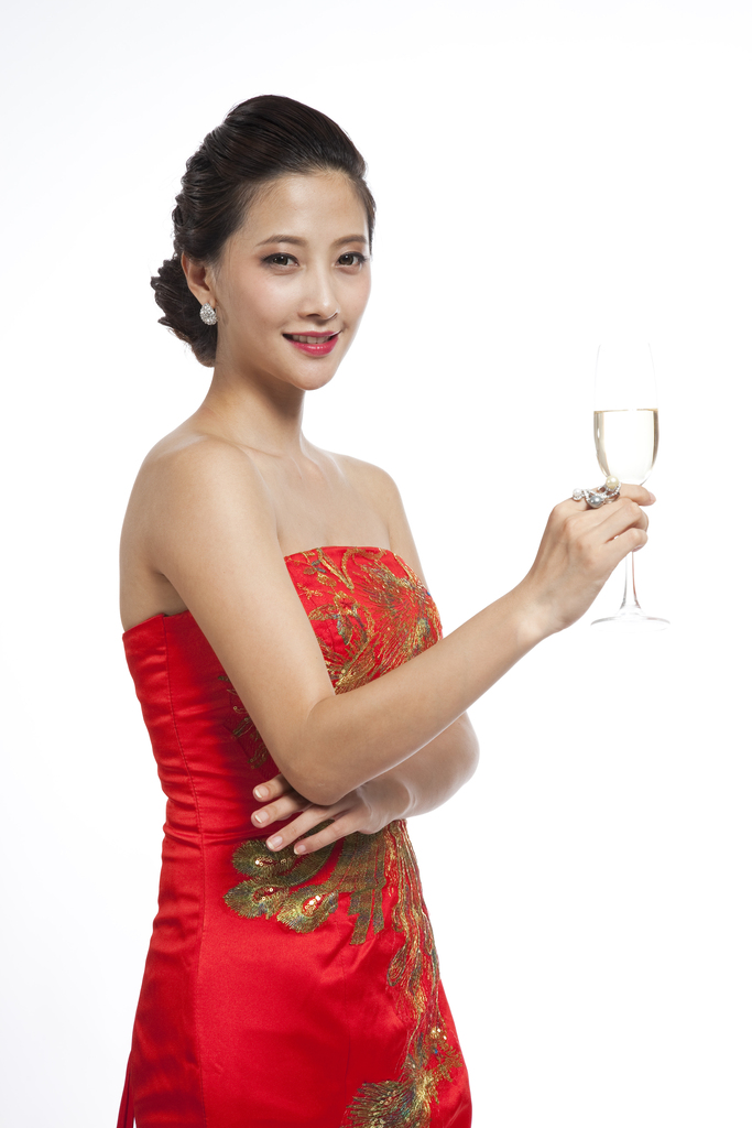 棚拍穿红色礼服的年轻女人端着香槟杯图片