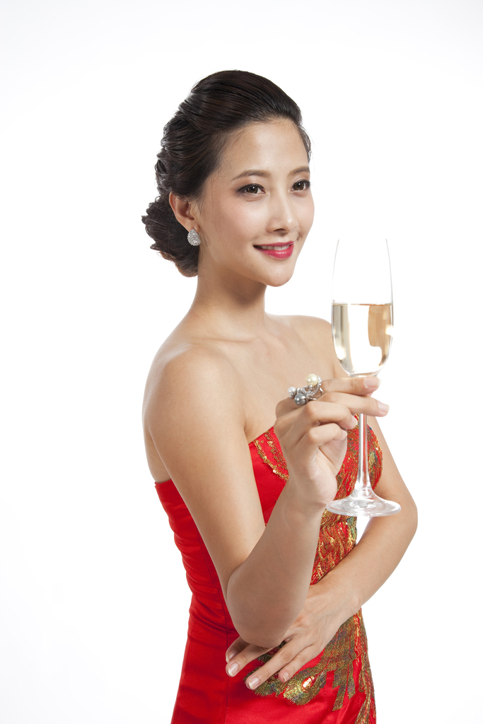 棚拍穿红色礼服的年轻女人端着香槟杯