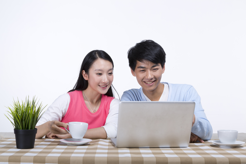 棚拍年轻情侣使用笔记本电脑图片