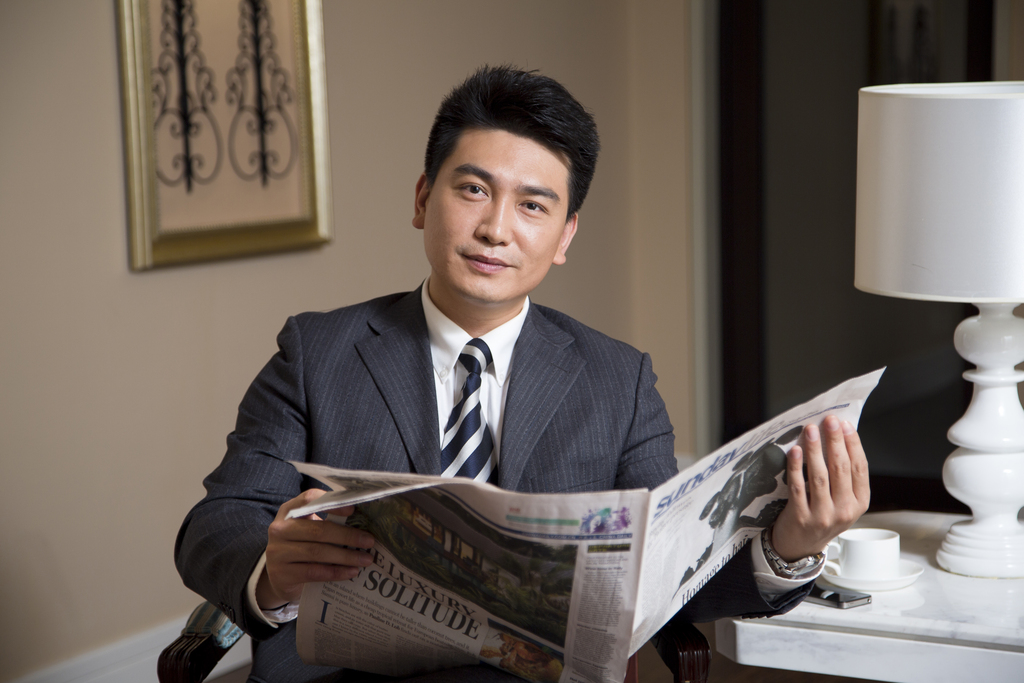 中年商务男士在书房看报纸