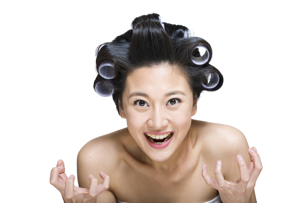 棚拍戴卷发棒的年轻女人图片