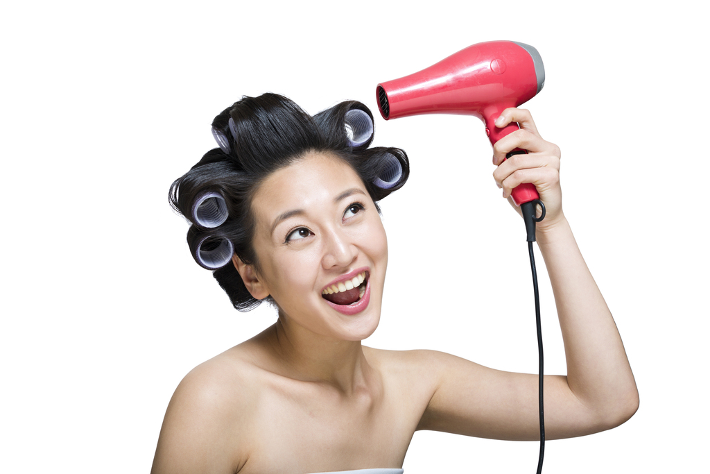 棚拍戴着卷发棒的年轻女人吹干头发