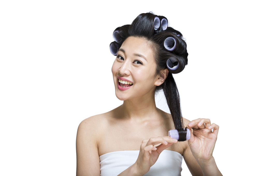 棚拍戴卷发棒的年轻女人图片
