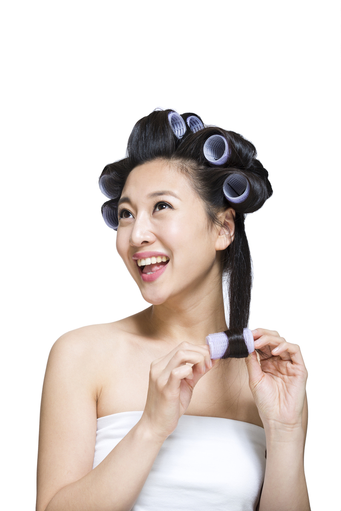 棚拍戴卷发棒的年轻女人