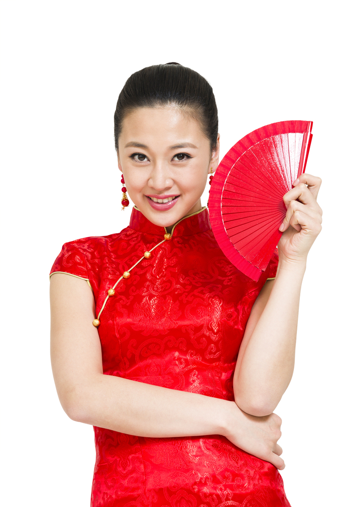 棚拍穿红色旗袍的年轻女人拿扇子