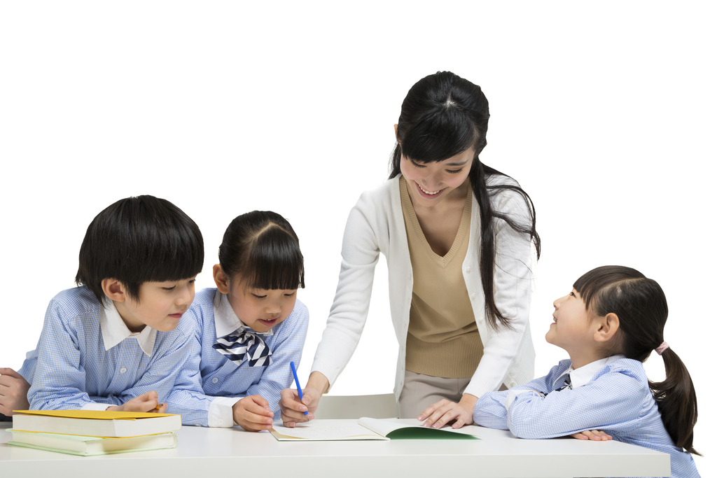 年轻女老师辅导小学生写作业图片