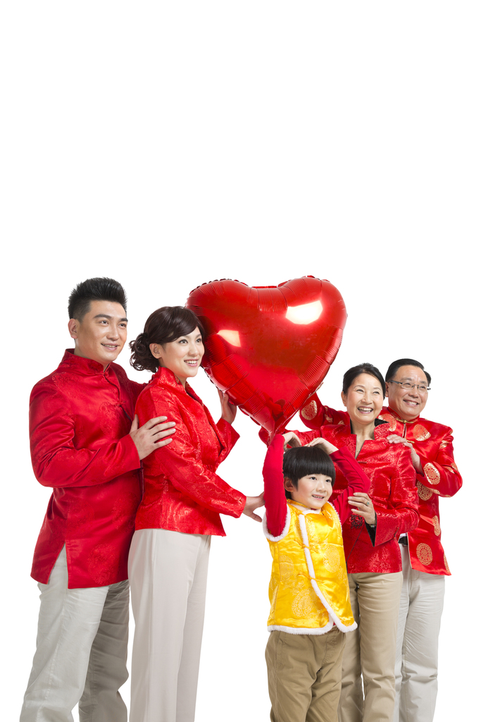 棚拍中国新年快乐的唐装家庭拿着红色桃心气球图片